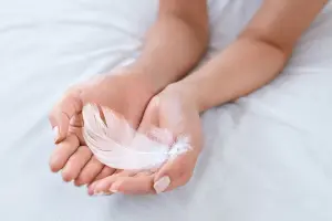 mani che reggono una piuma